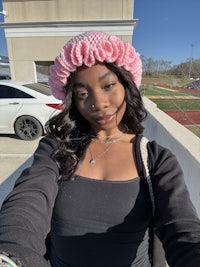 a woman wearing a pink scrunchie hat
